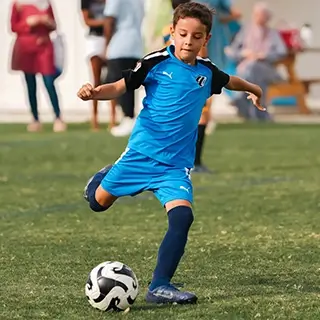 Child Engaged in Children's Football: Soccer Kick