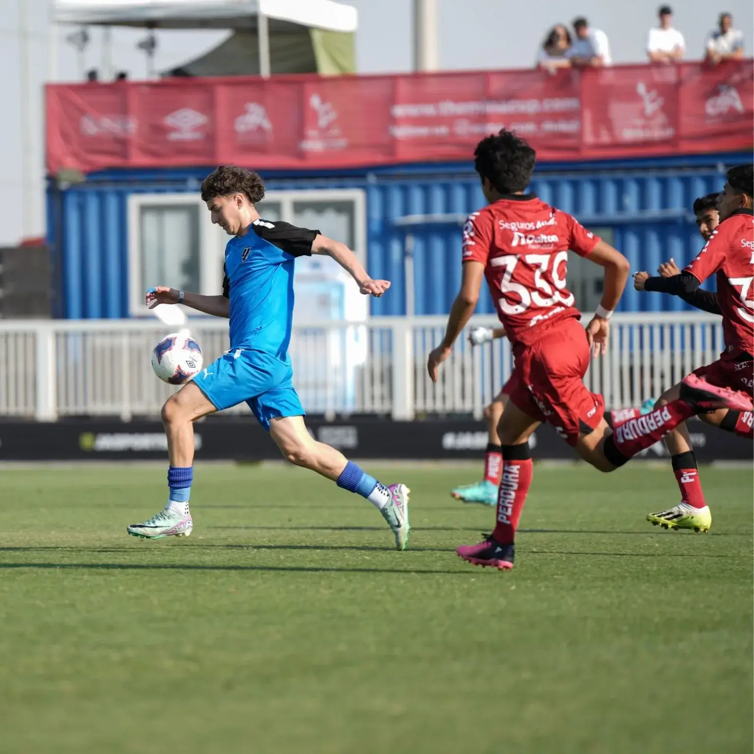 Mina Cup 2024 | A group of young men playing football on a field .