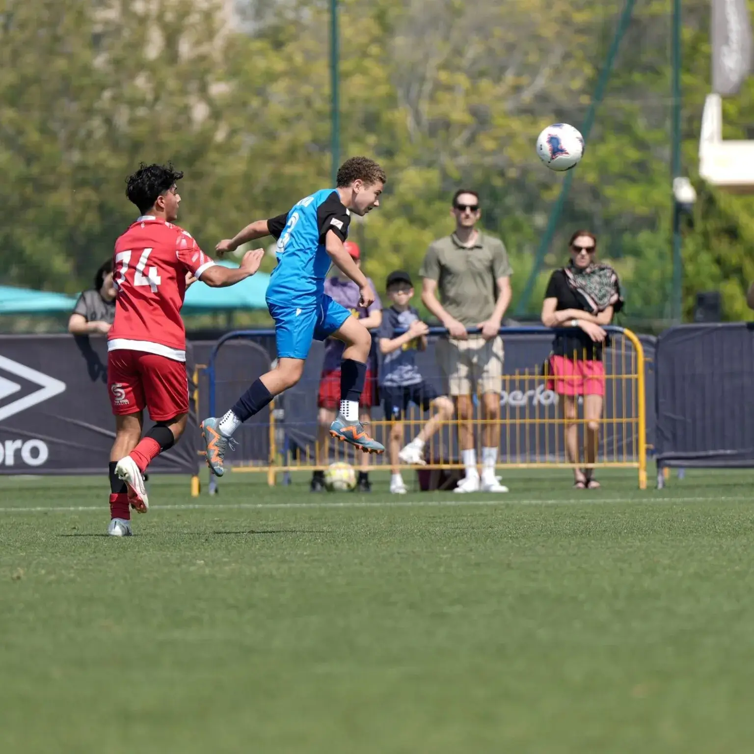 A lively soccer game being played by a group of people in an open field.