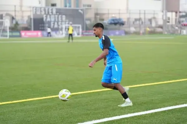 football training in dubai | A player in a blue jersey kicking a soccer ball as part of High Performance program