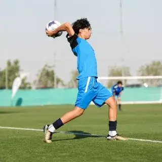 A player in getting ready to throw a ball outdoors.