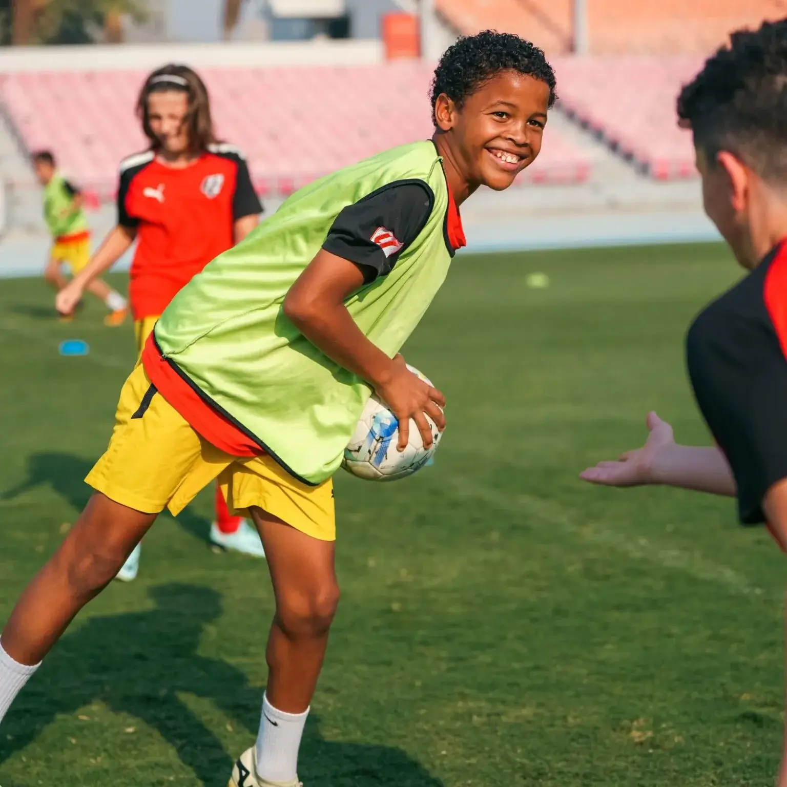 A young boy happily playing football during a training session before IBER Cup.