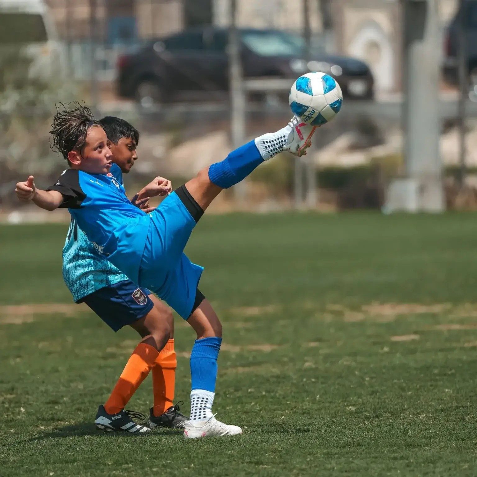 DOFA Season 2023 | A young boy in a blue jersey kicking a soccer ball