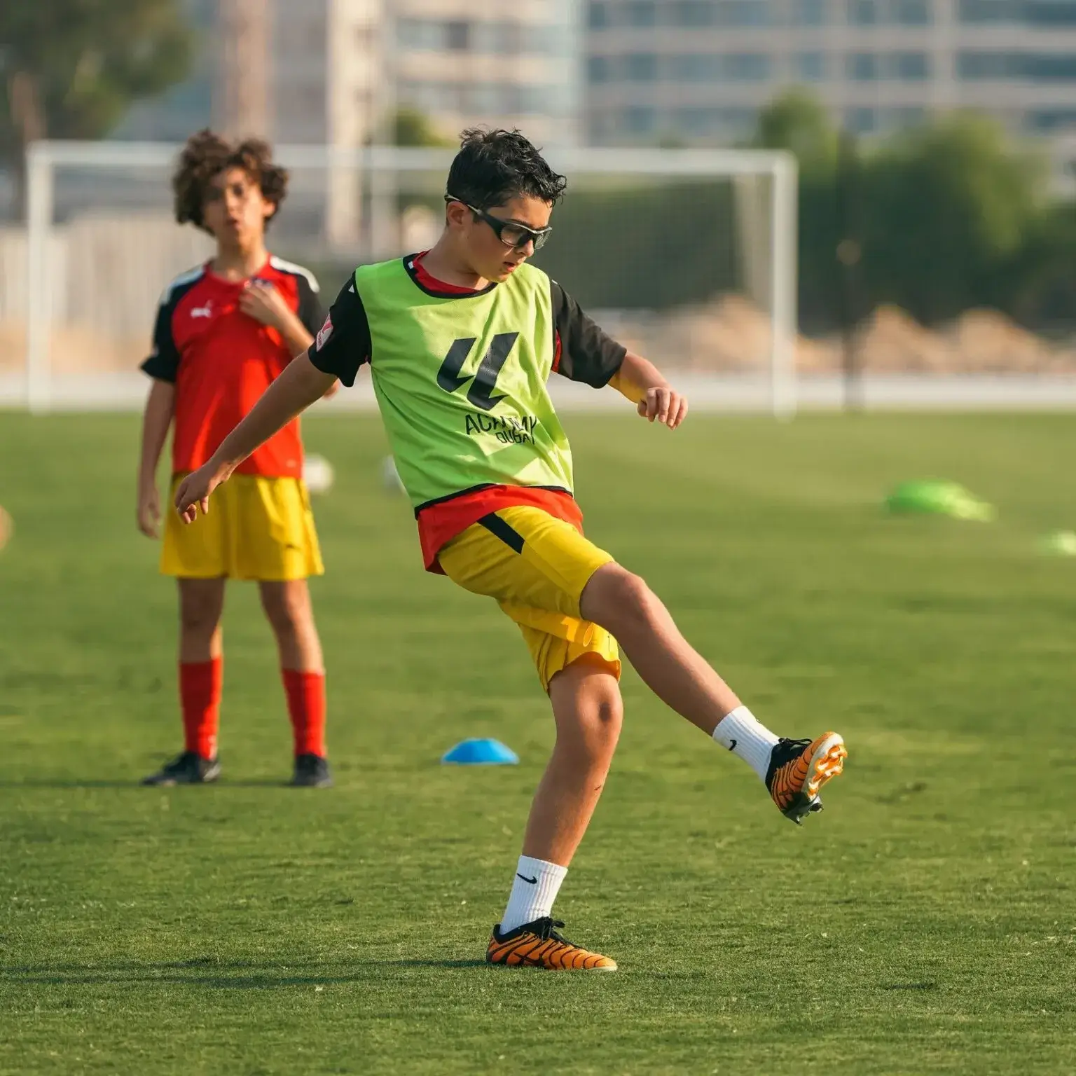 A young boy kicks a soccer ball on a field during the last training session before IBER Cup.