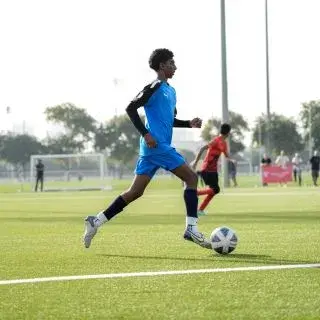 Young Man Playing Soccer in Blue Uniform | Football Classes Near Me