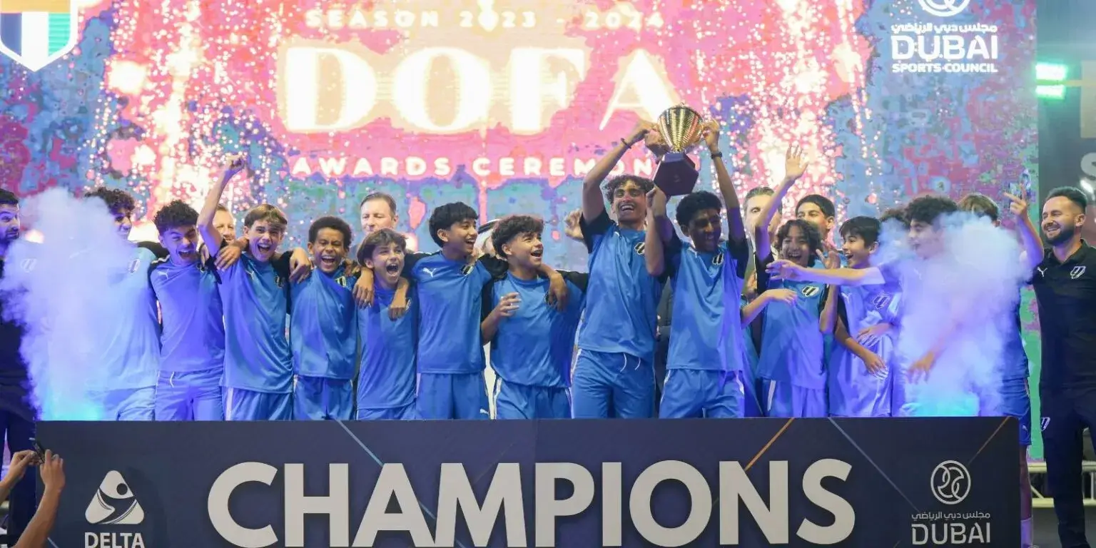 Group of players celebrating with trophy after DOFA Season tournament victory.