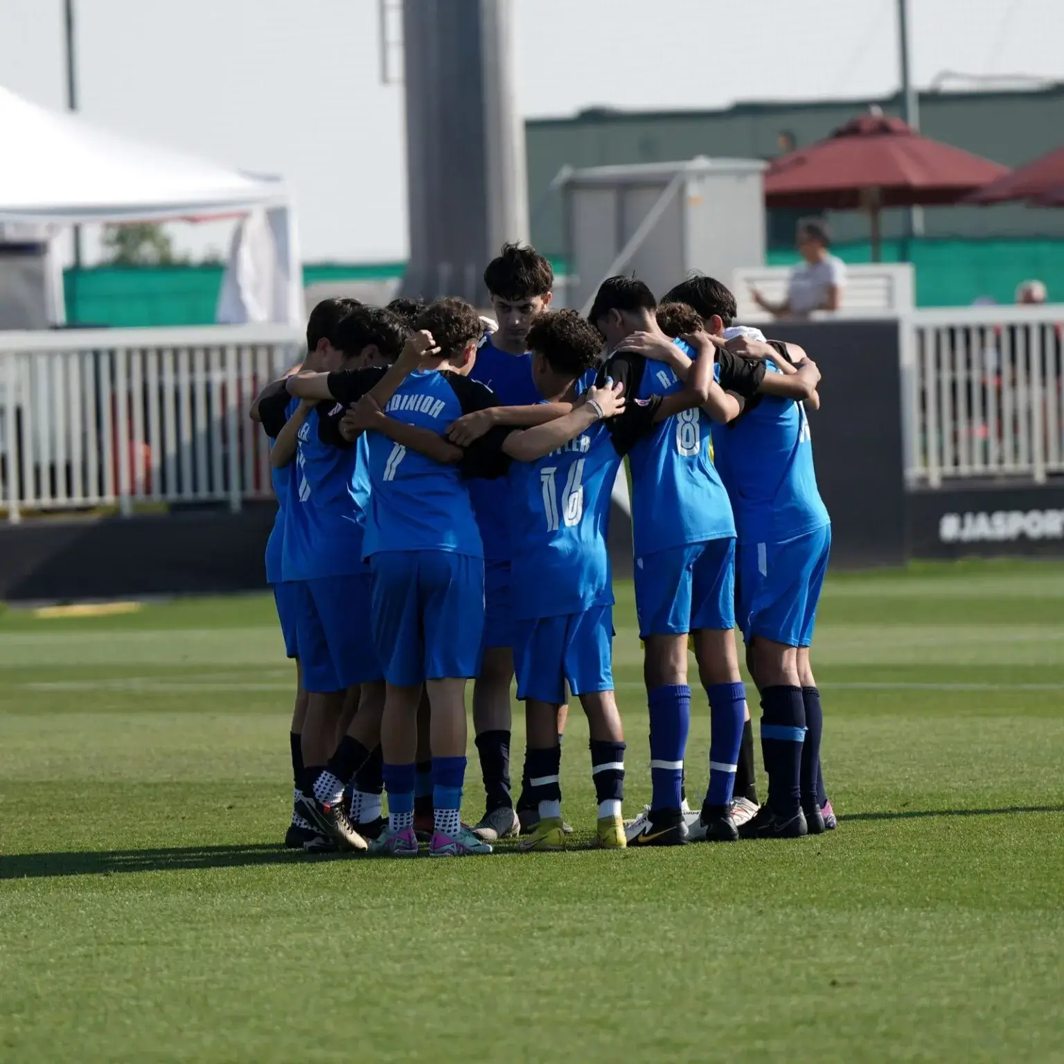 People of various backgrounds gathered closely in a huddle.