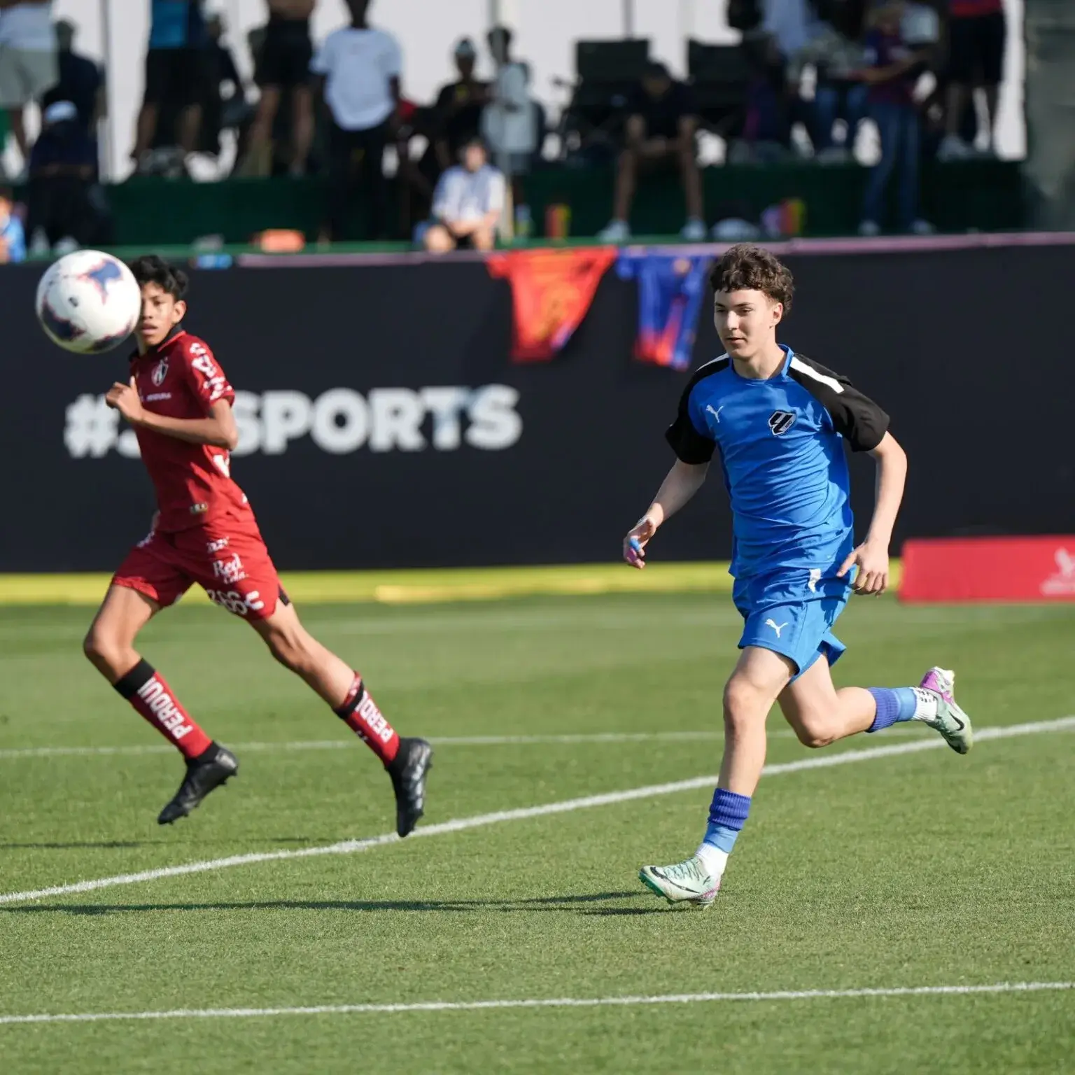 Two young men playing soccer on a field | Mina Cup 2024.