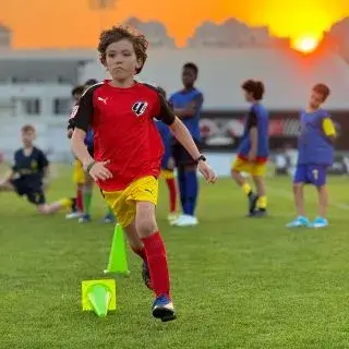 Young Boy in Red Running with Soccer Ball | LaLiga Academy Dubai