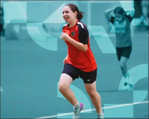 Girls Football | Young female athlete in red shirt sprinting across soccer field.