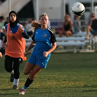 Young Female Athletes Playing Soccer Outdoors | Girls Football